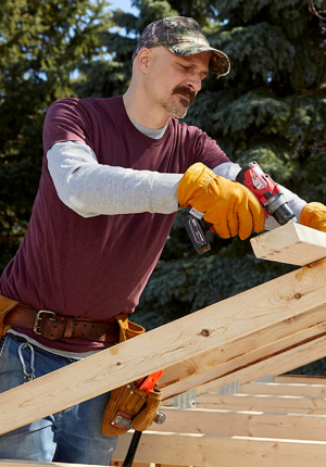 Trabajador construye la estructura de madera de una casa