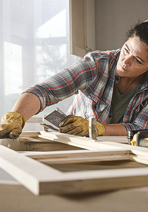 Female carpenter building a cabinet door