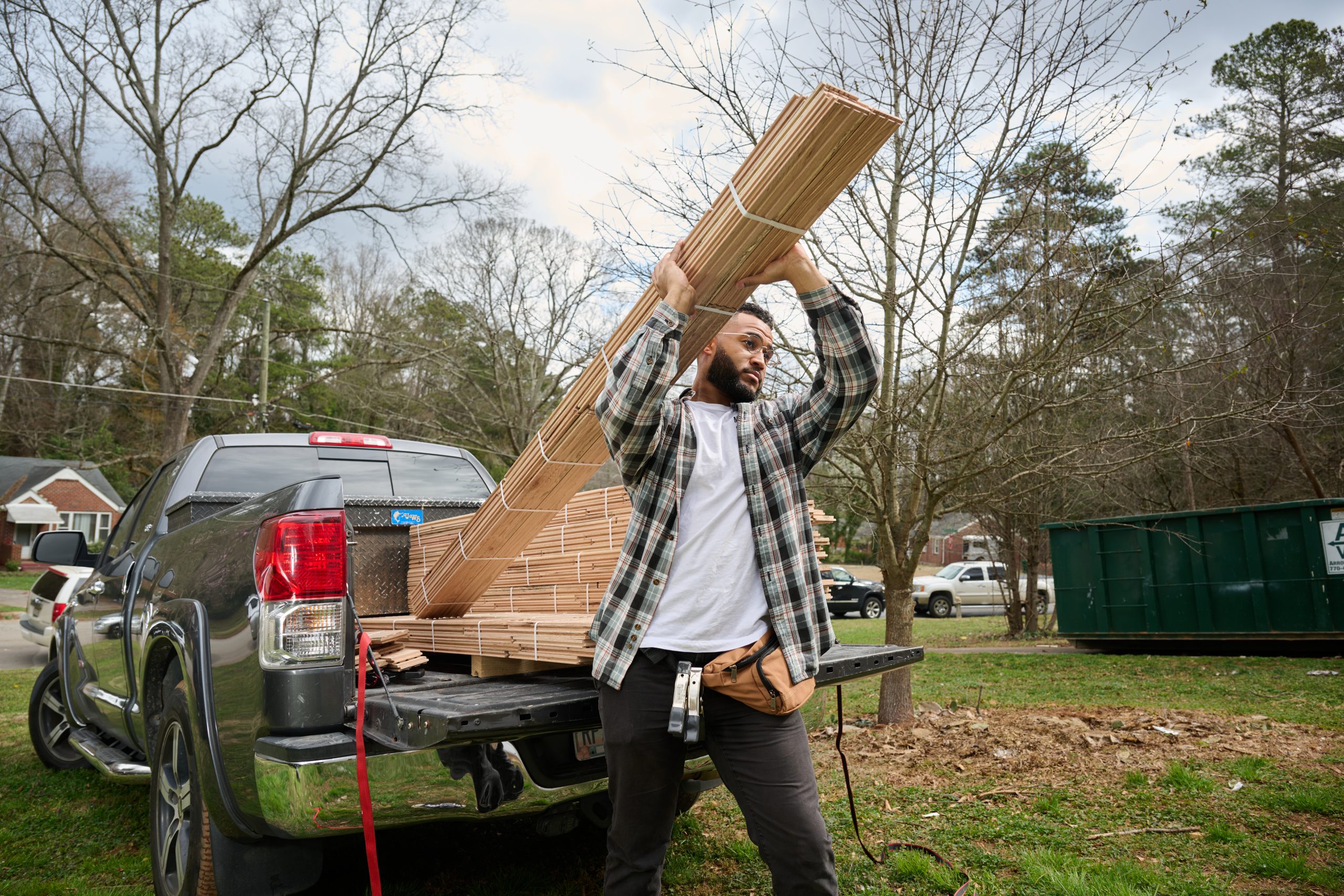 Hombre afroamericano descargando madera de un camión de trabajo