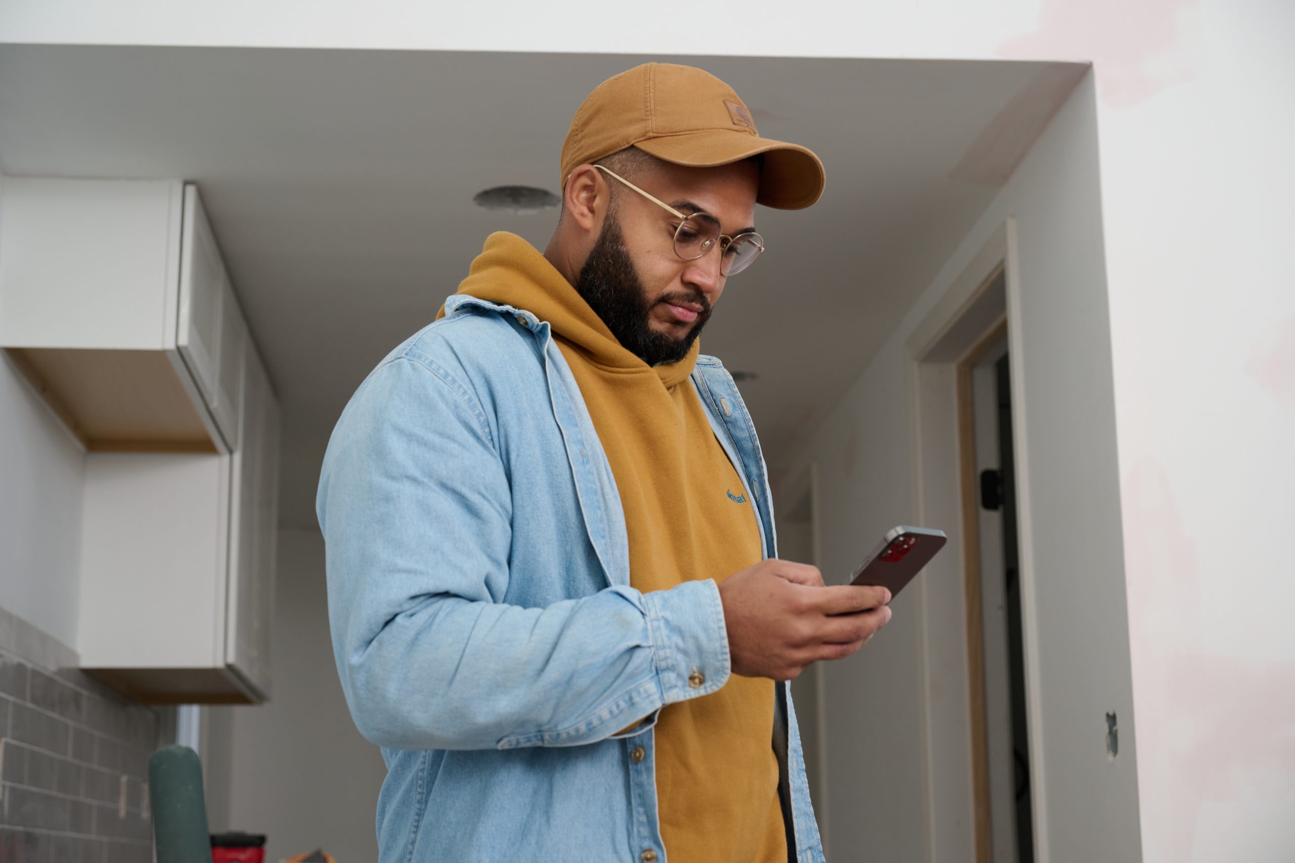 African American male looking down at his cell phone in his hand