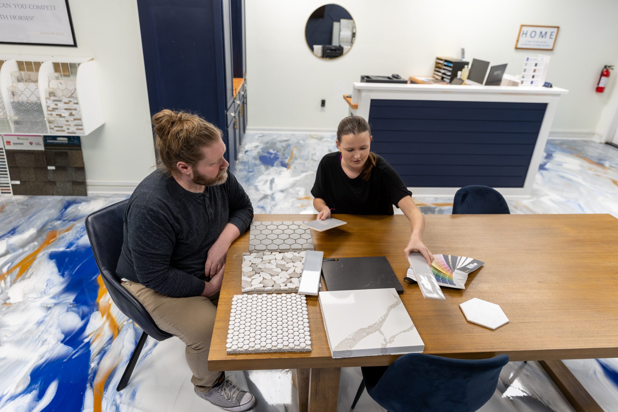 Caucasian male and female reviewing design selections in a showroom